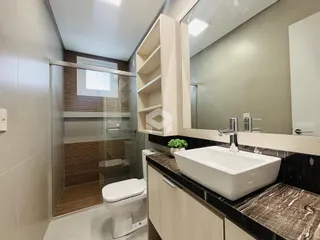 Foto de um banheiro moderno com box de vidro e revestimento de mármore escuro.
