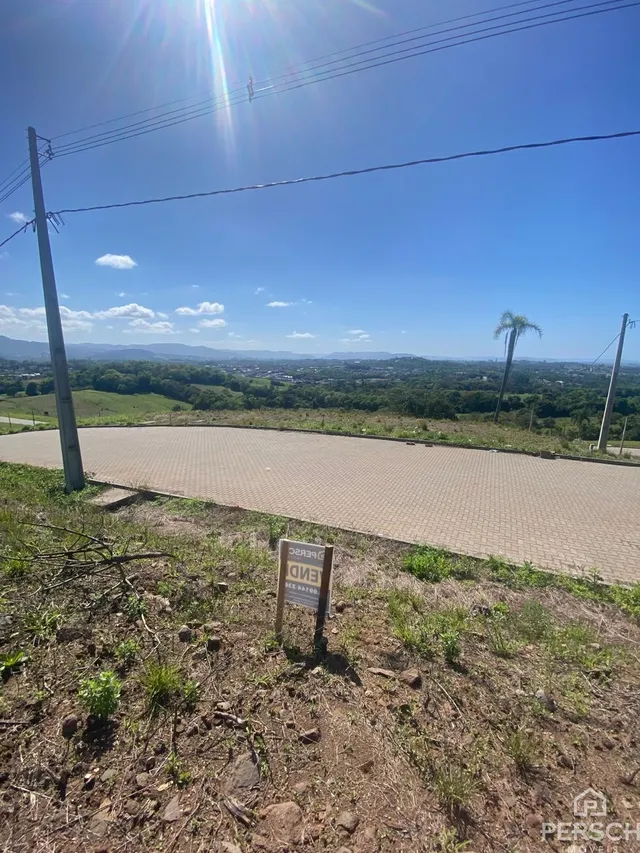 Vista panorâmica de campos e colinas sob um céu azul claro.