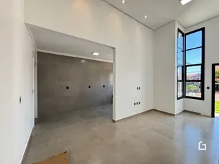 Ambiente interno com paredes brancas e piso de concreto em uma residência.