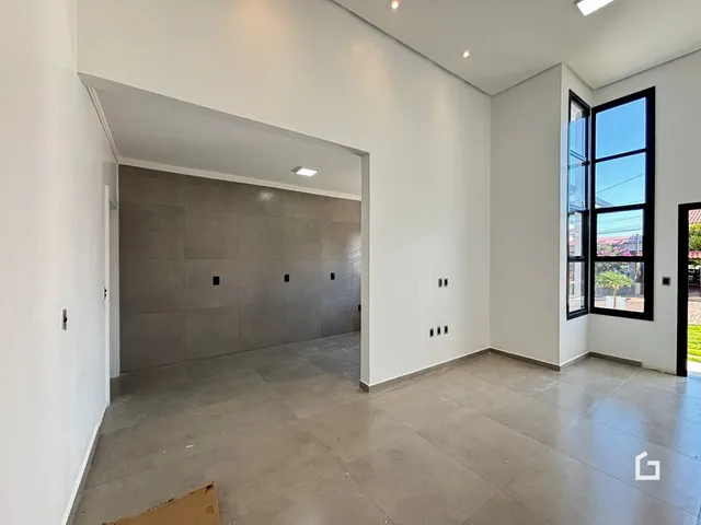 Ambiente interno com paredes brancas e piso de concreto em uma residência.