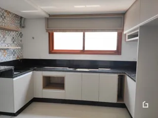 Cozinha com armários brancos e bancadas escuras.