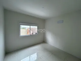 Sala de um imóvel com piso de mármore claro e janela.