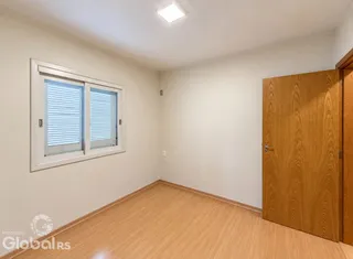 Ambiente interno com piso de madeira e janela.