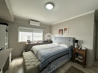 Quarto com cama grande e piso de madeira.