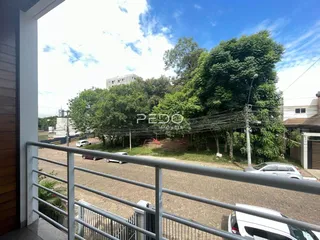 Vista externa de uma propriedade com vegetação densa ao fundo.
