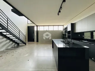 Ambiente de sala de estar e cozinha com escadaria em um imóvel em Lajeado.