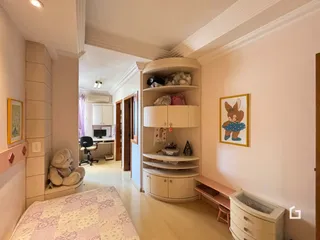 Hall de entrada com piso de madeira e parede branca em uma residência.
