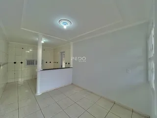 Interior de um ambiente com piso de cerâmica claro e paredes brancas.