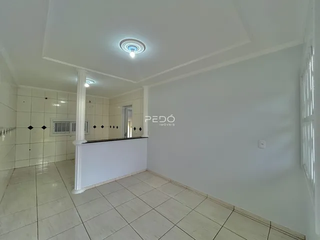 Interior de um ambiente com piso de cerâmica claro e paredes brancas.