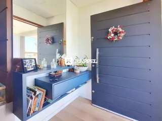 Hall de entrada com prateleira e porta cinza em ambiente residencial.