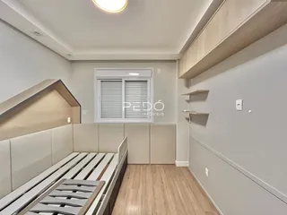 Quarto com cama de madeira e piso de madeira clara.