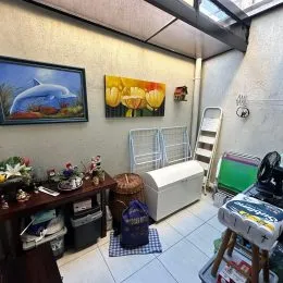 Foto interna de uma sala com parede decorada e móveis.
