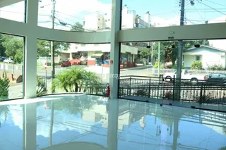 Vista interna de uma sala com grandes janelas refletindo o exterior.